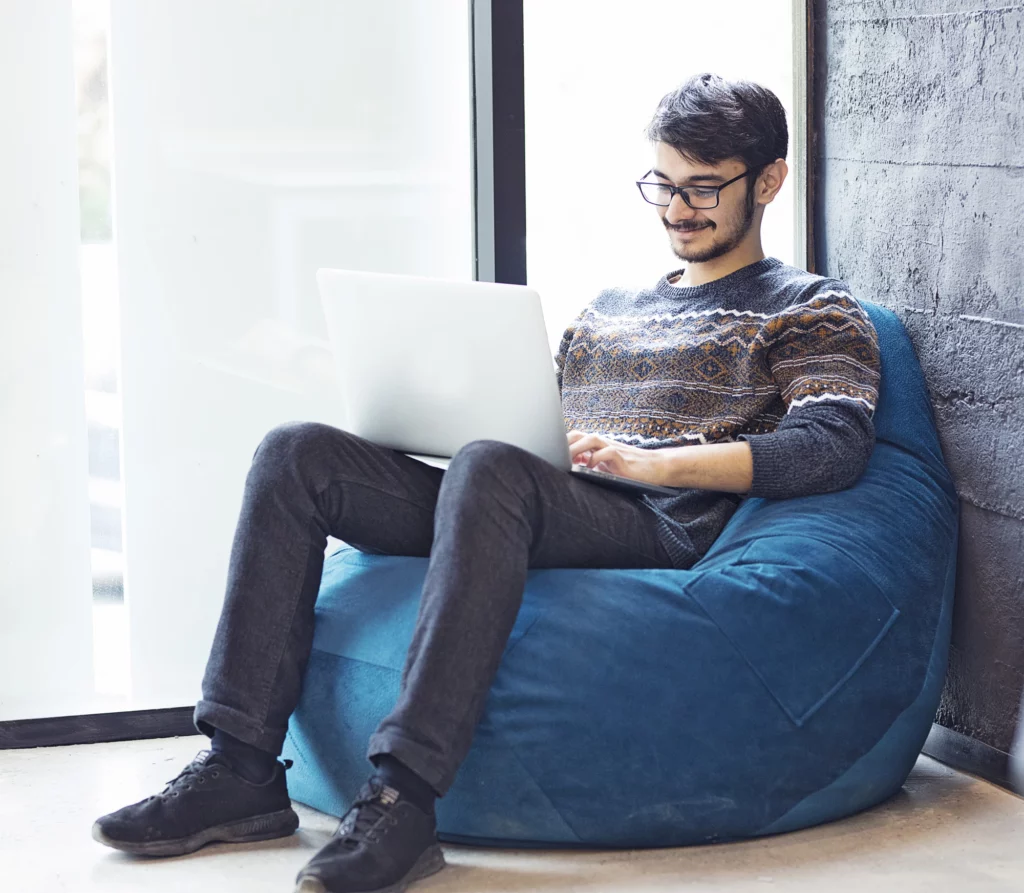 free-office-space-male-employee-sitting-window-with-his-laptop